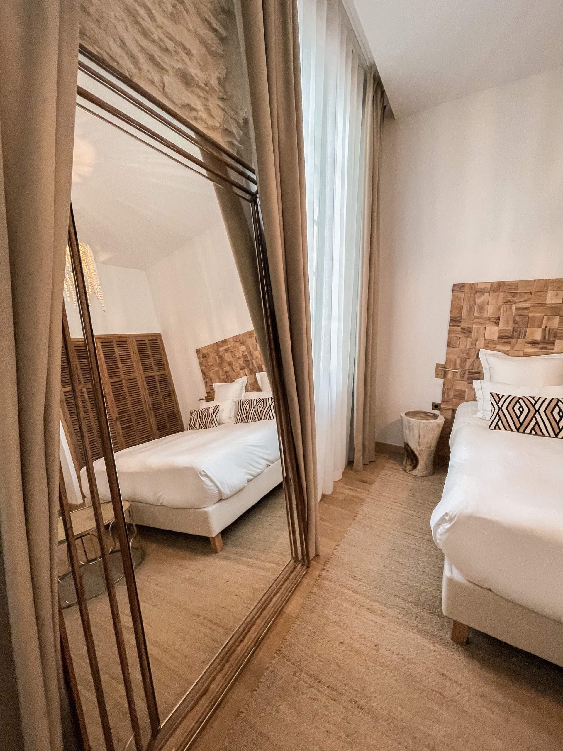 Chambre élégante avec un grand miroir et lit.