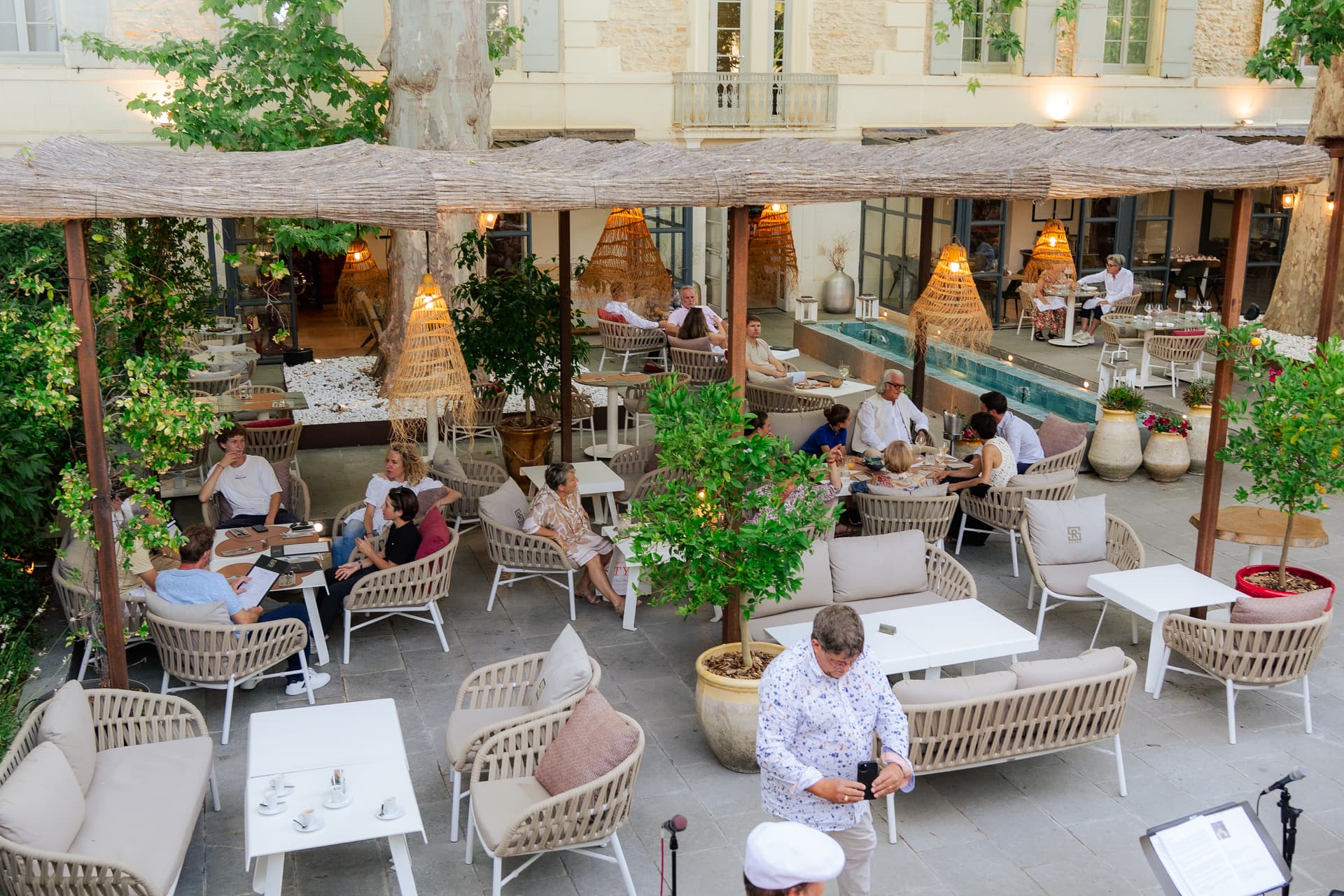 Terrasse élégante avec convives sous lanternes en osier
