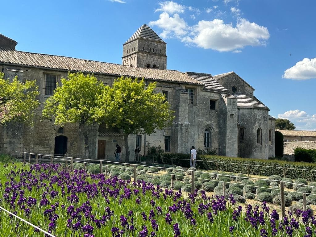 Abbaye avec fleurs violettes au premier plan.