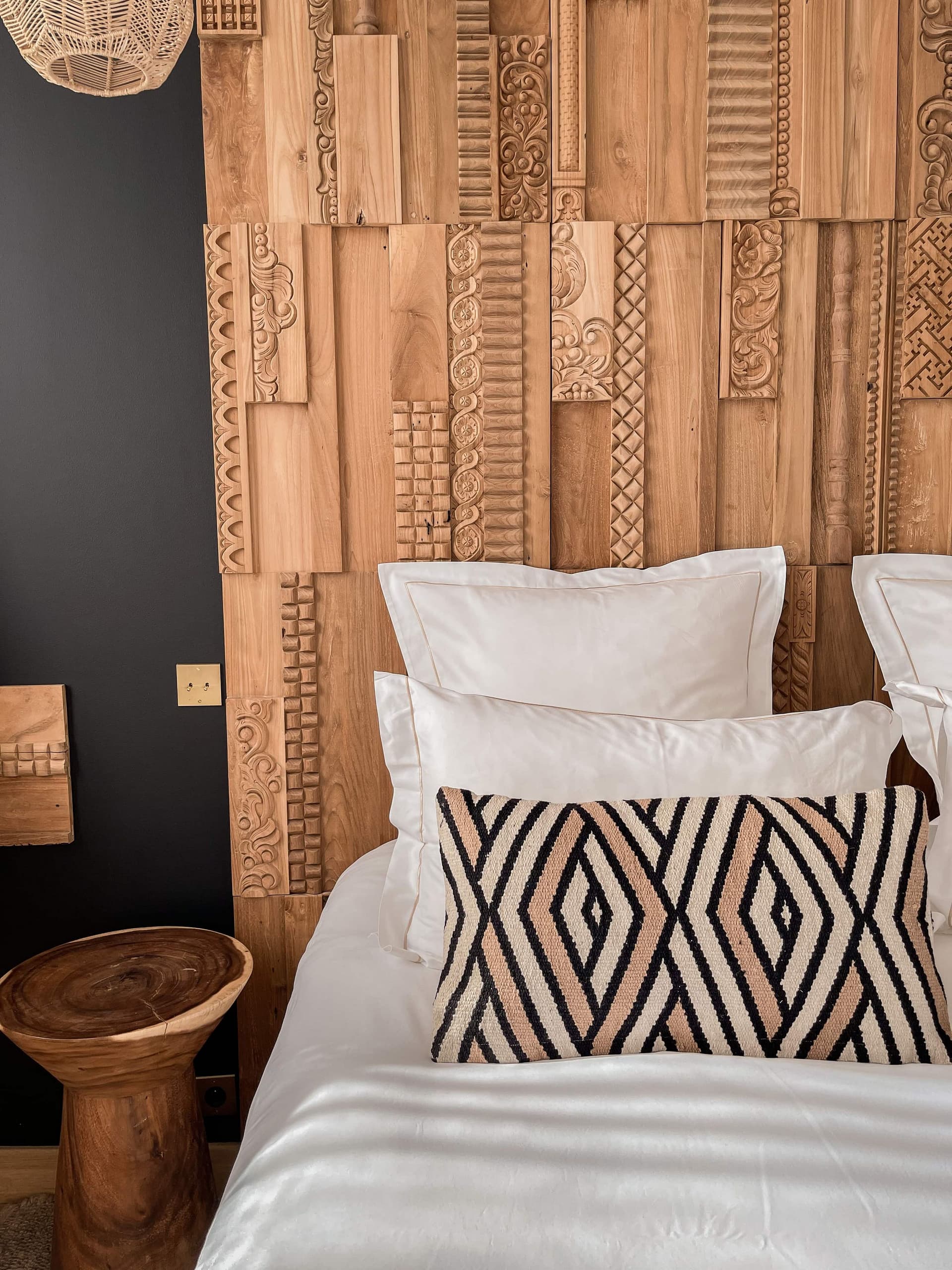Chambre avec tête de lit en bois sculpté.