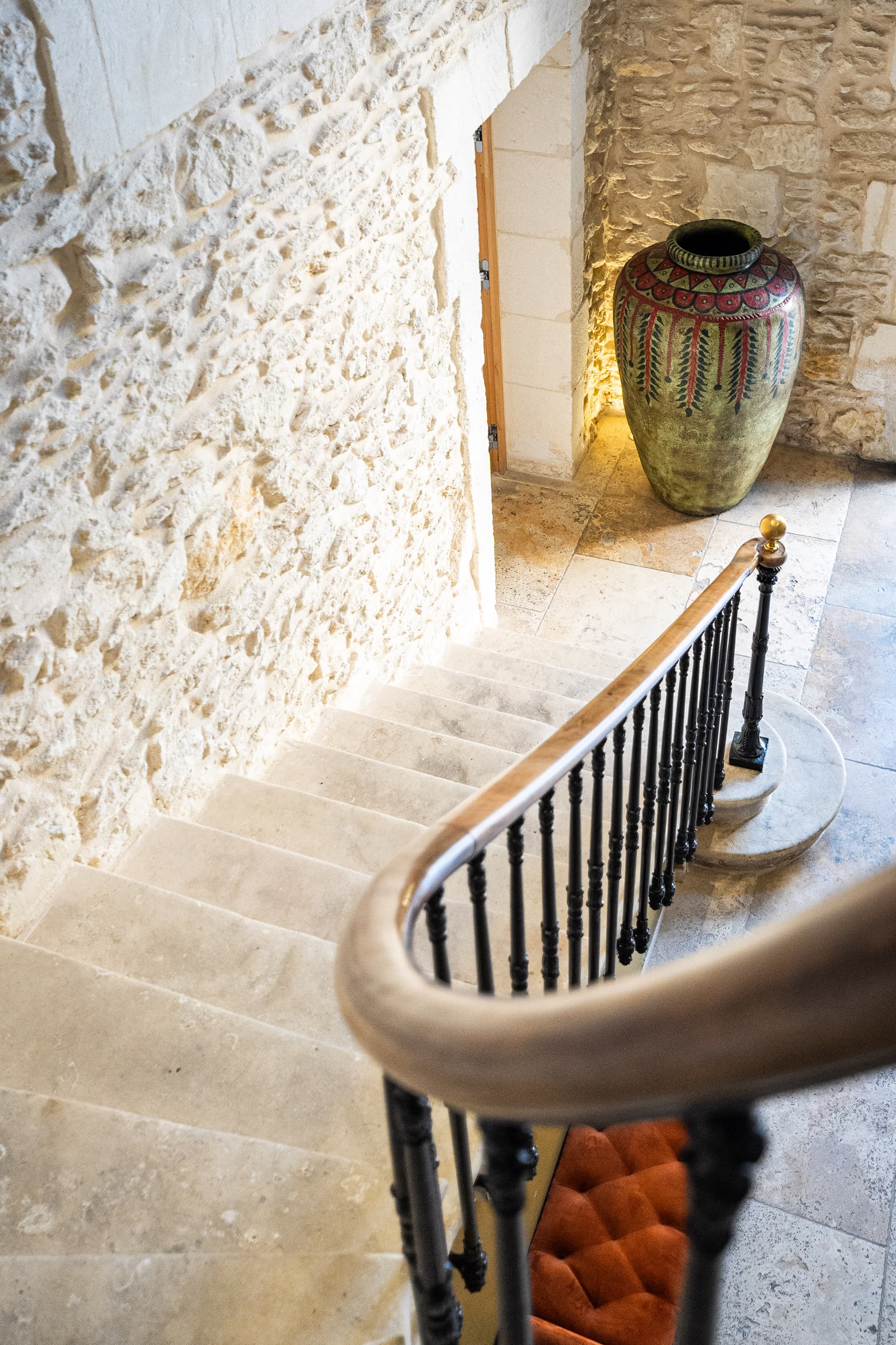 Escalier en pierre avec un grand vase décoratif.