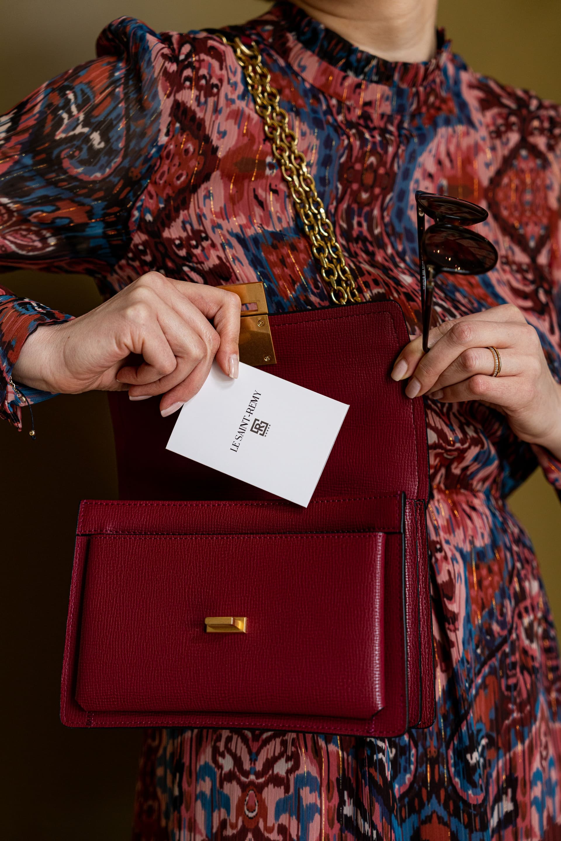 Main tenant un sac rouge et une carte blanche.