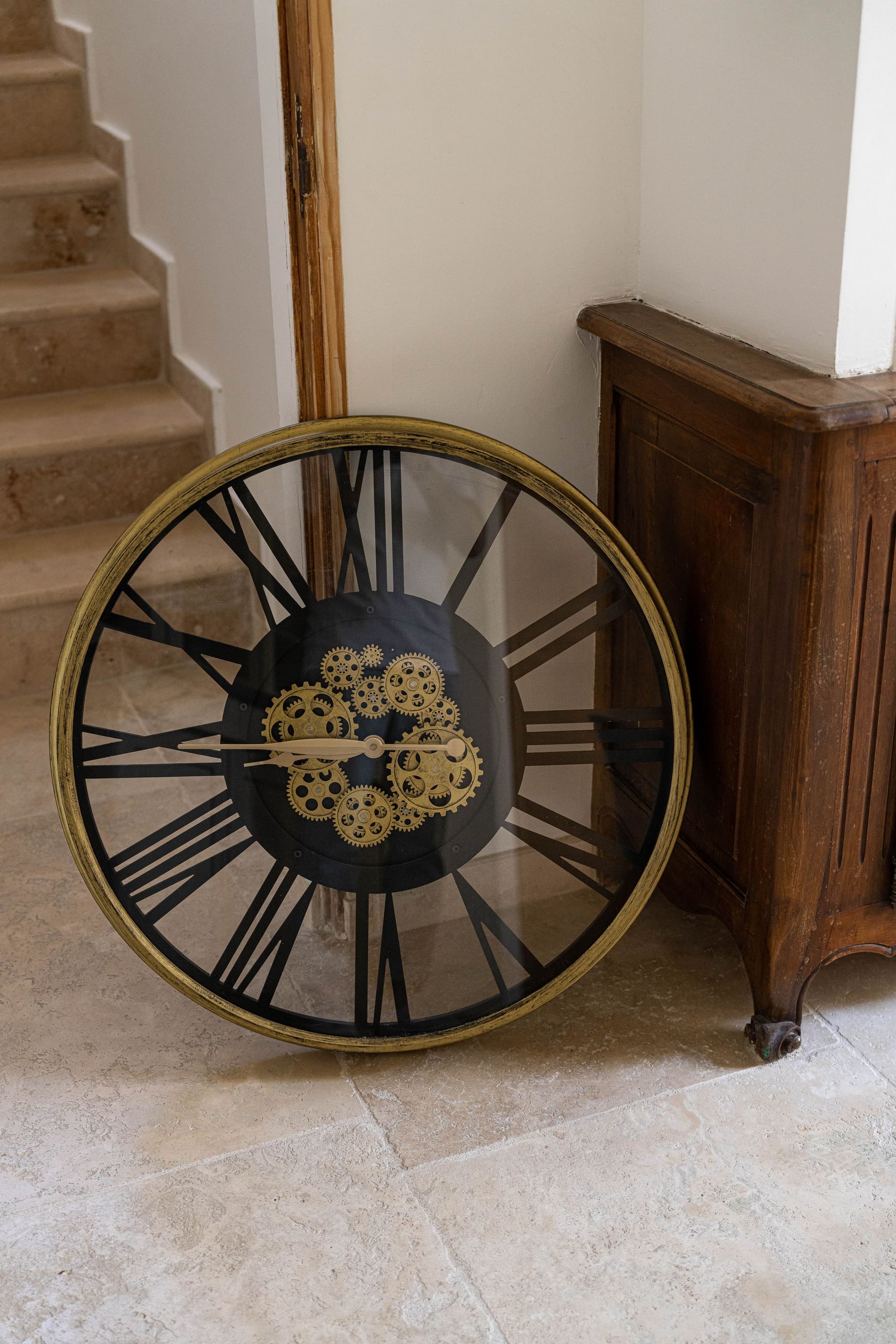 Grande horloge murale posée près des escaliers.