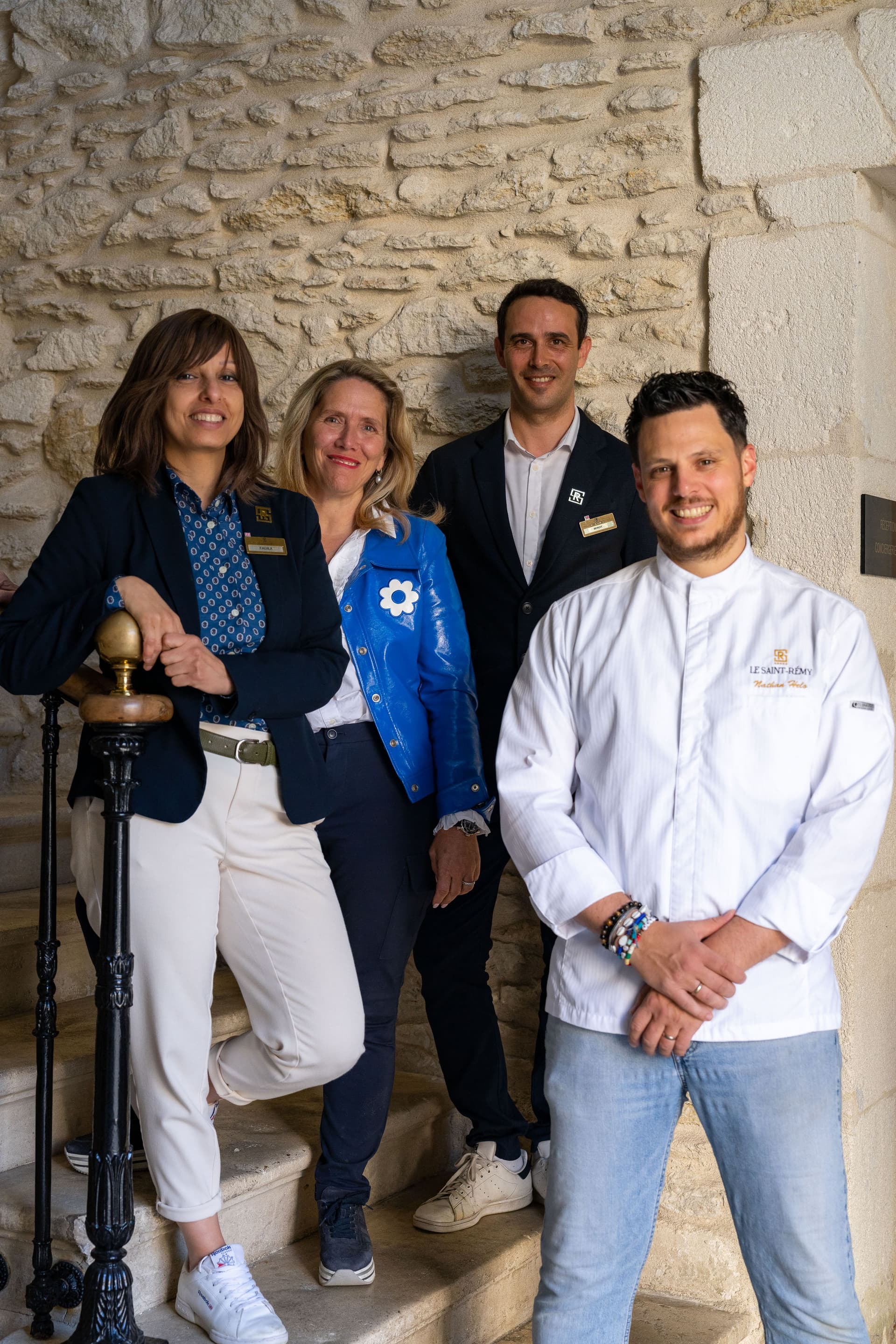 Quatre personnes posent sur un escalier en pierre.