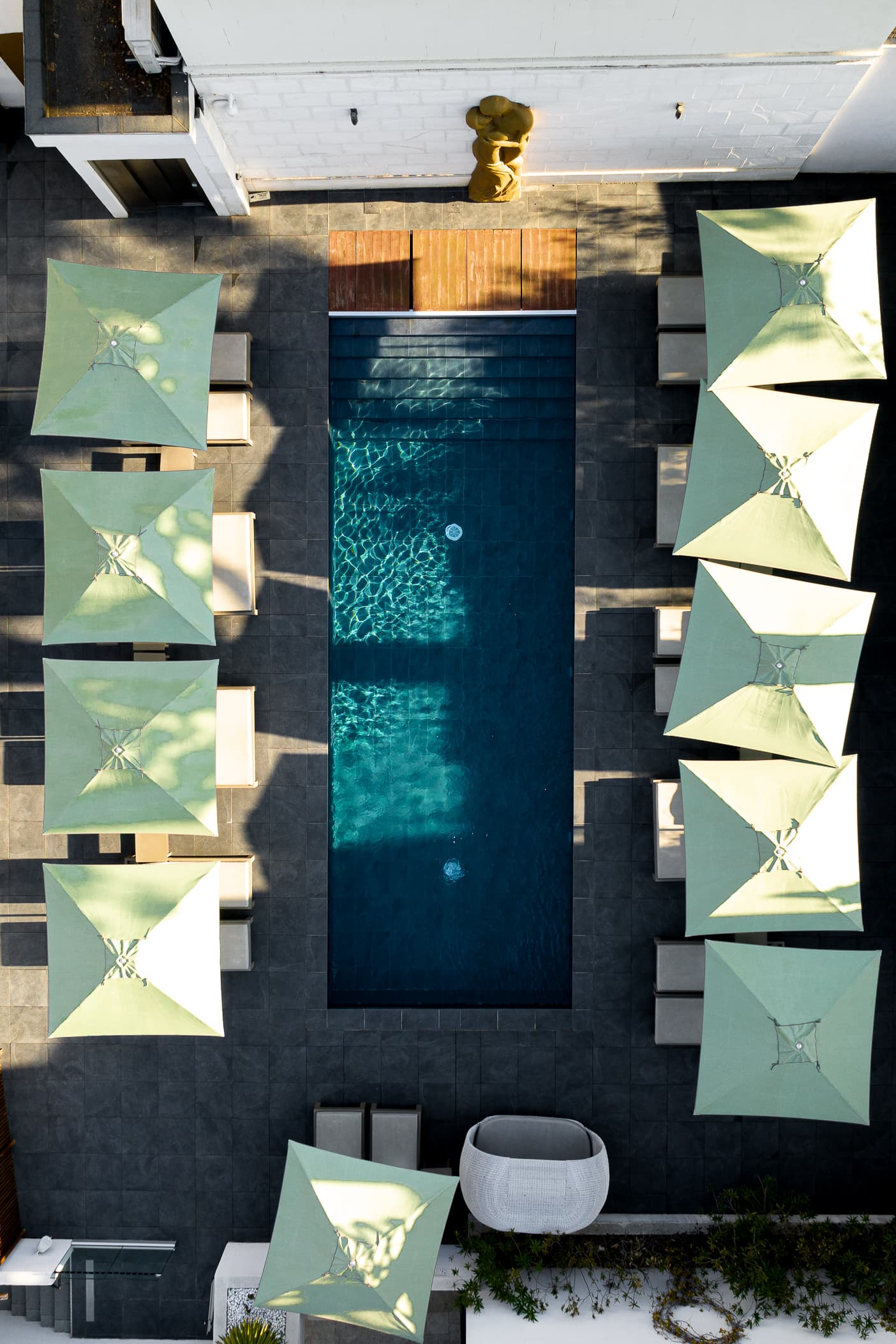 Vue aérienne d'une piscine entourée de parasols.