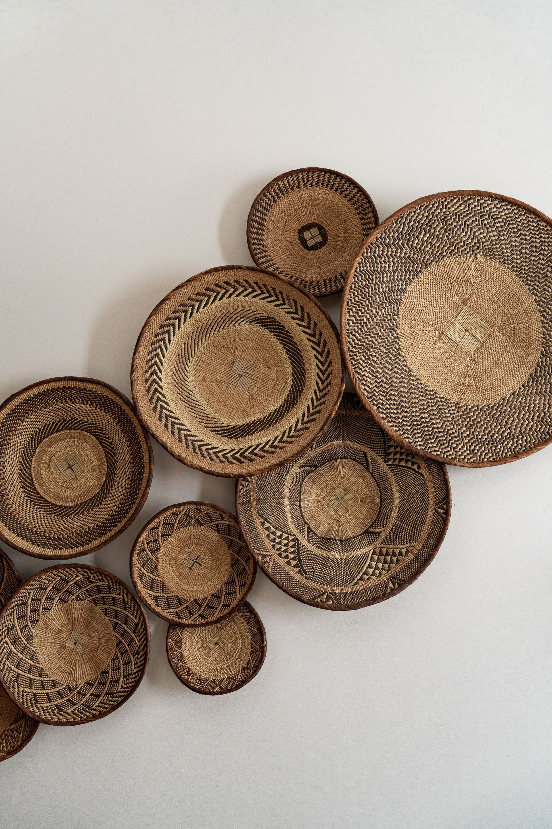 Paniers en osier tressé accrochés au mur.