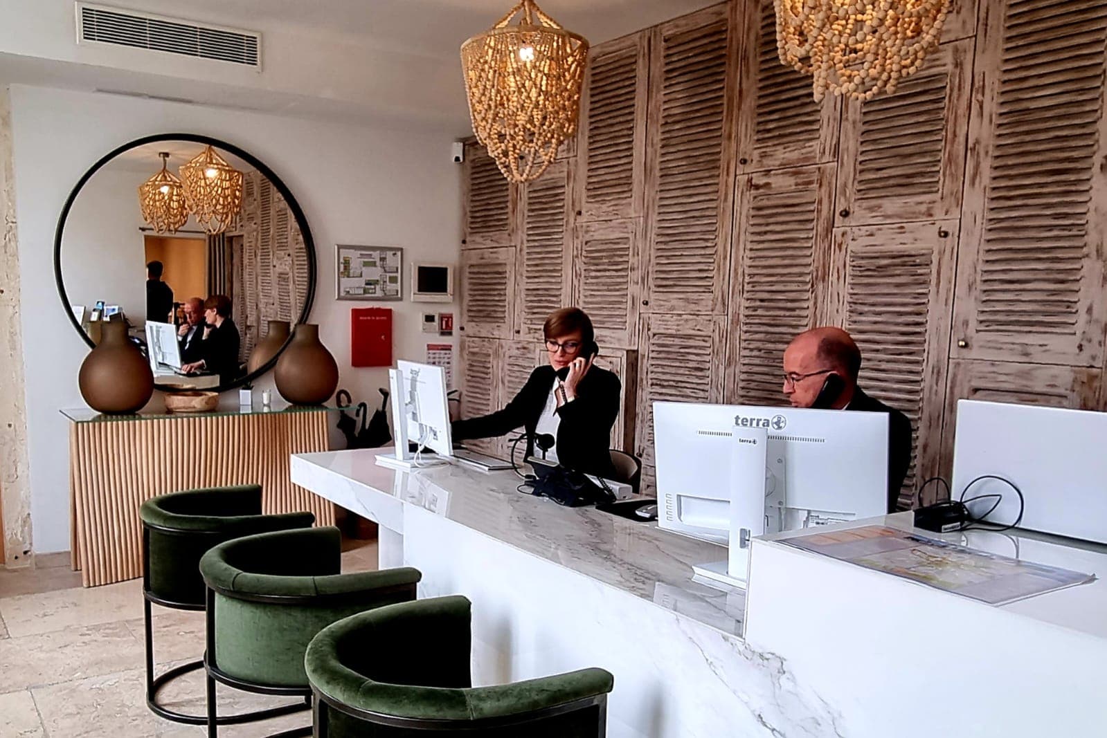 Réception d'hôtel avec personnel et ordinateurs.