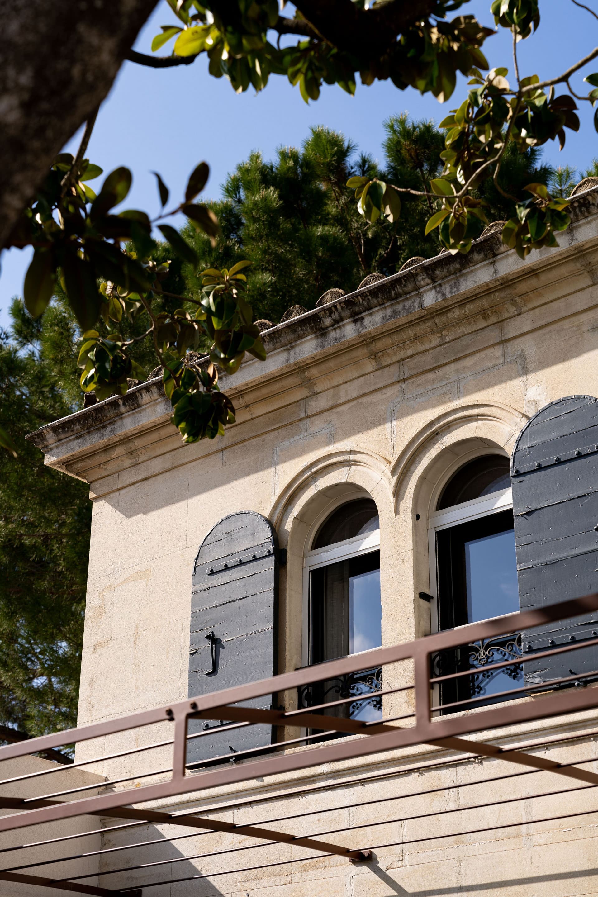 Fenêtre avec volets noirs sur bâtiment ancien.