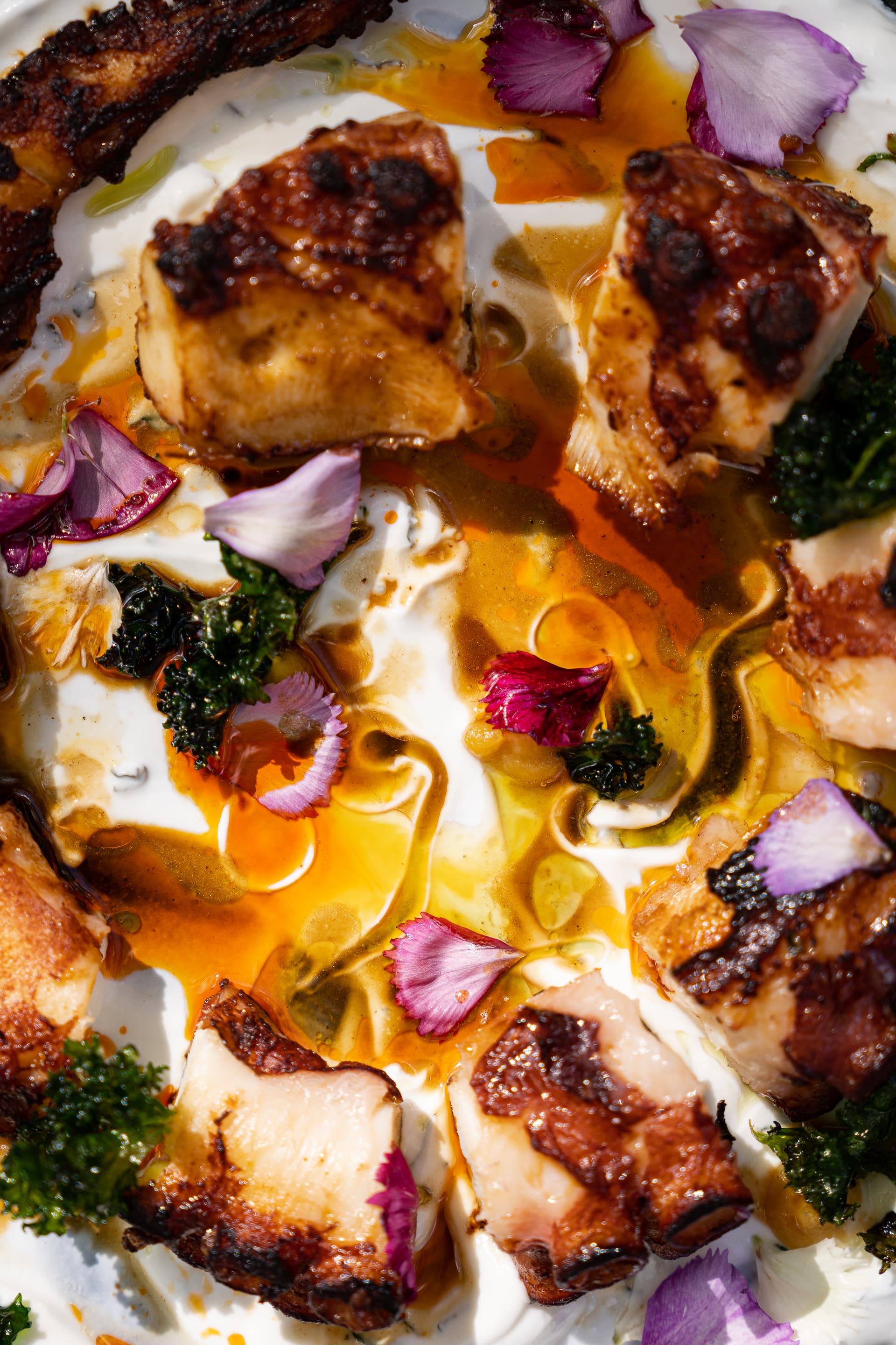 Plat gastronomique coloré avec fleurs et sauce.