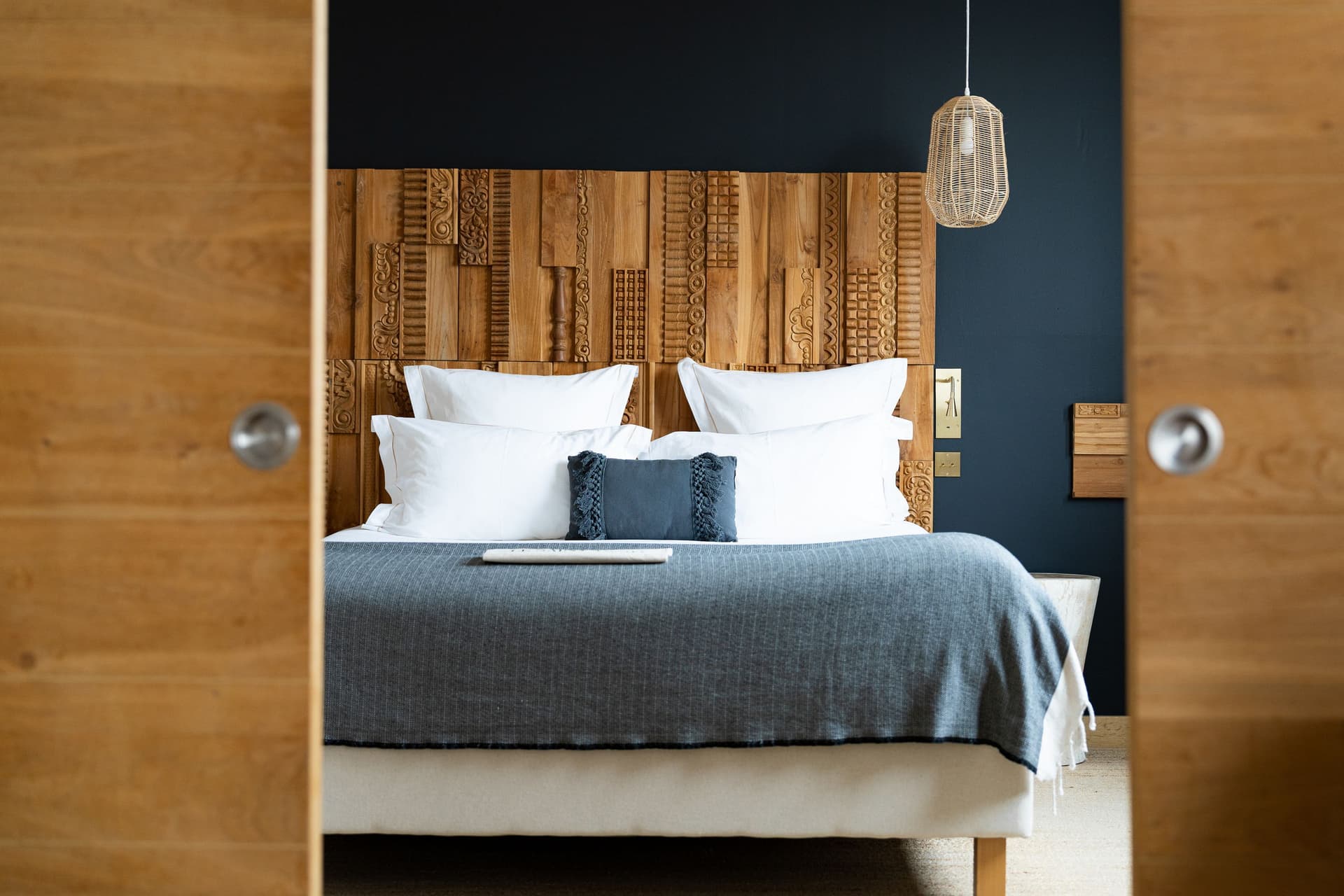 Chambre avec lit et tête de lit décorative.