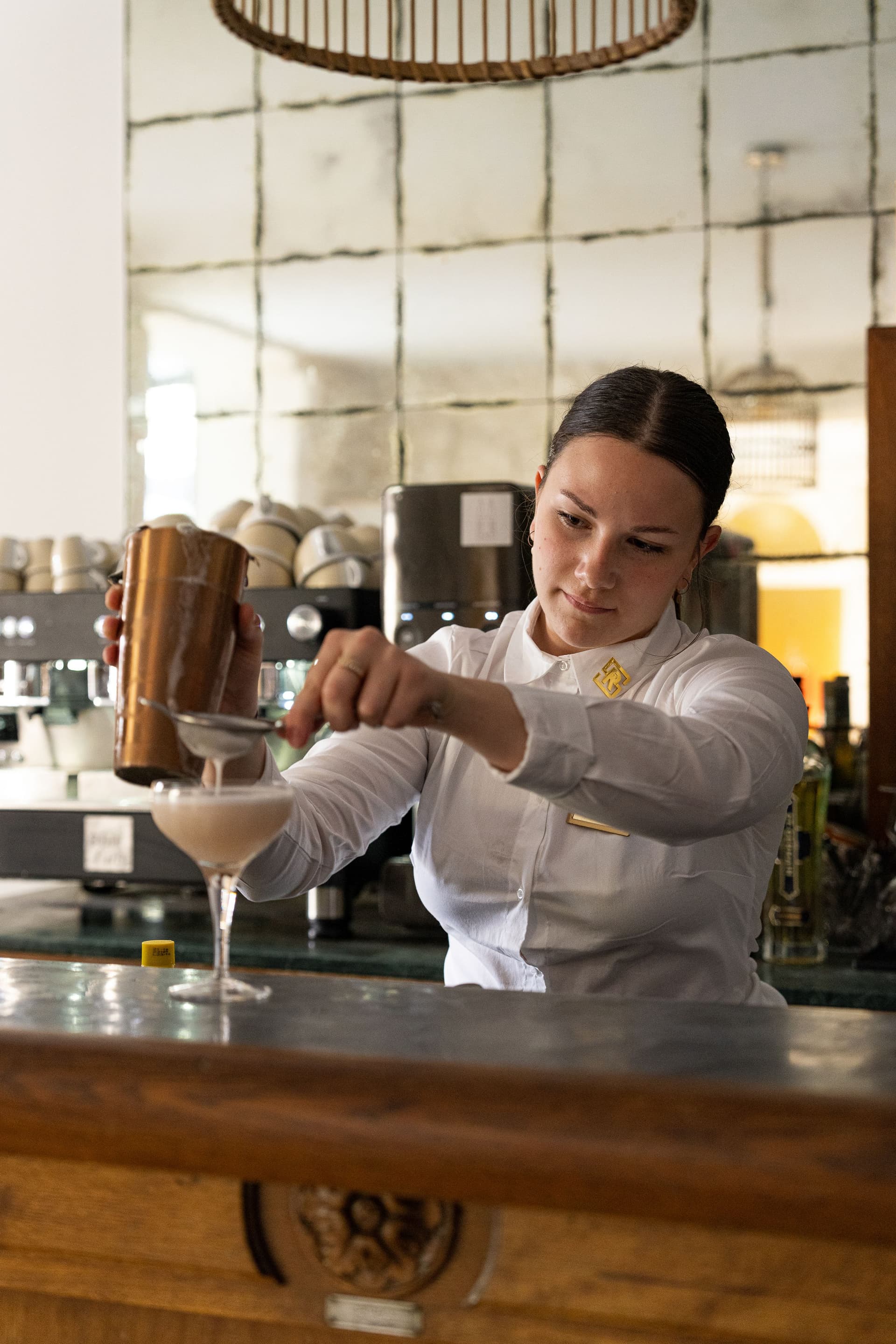 Serveuse préparant un cocktail au bar.