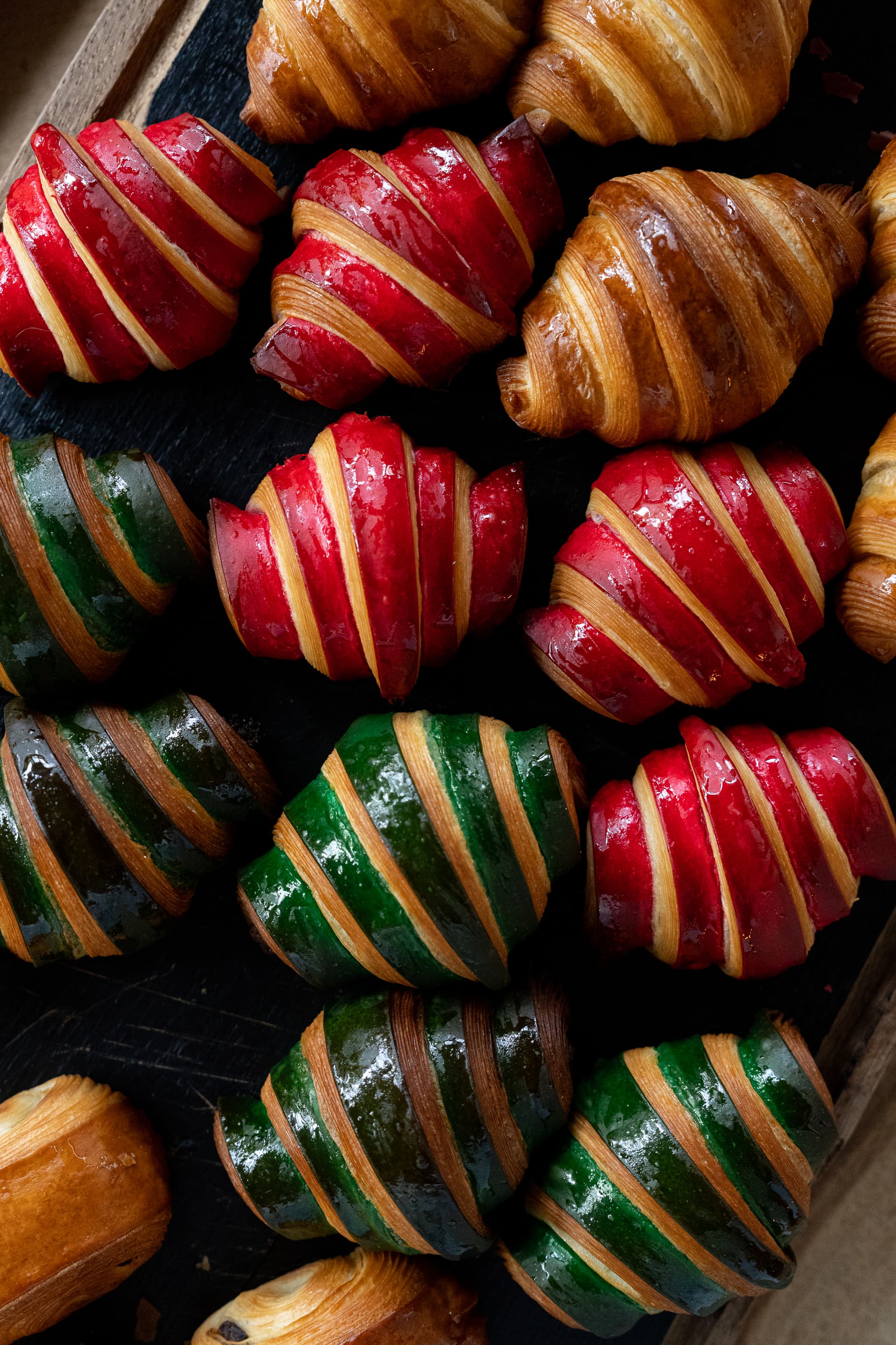 Croissants colorés verts et rouges sur un plateau.