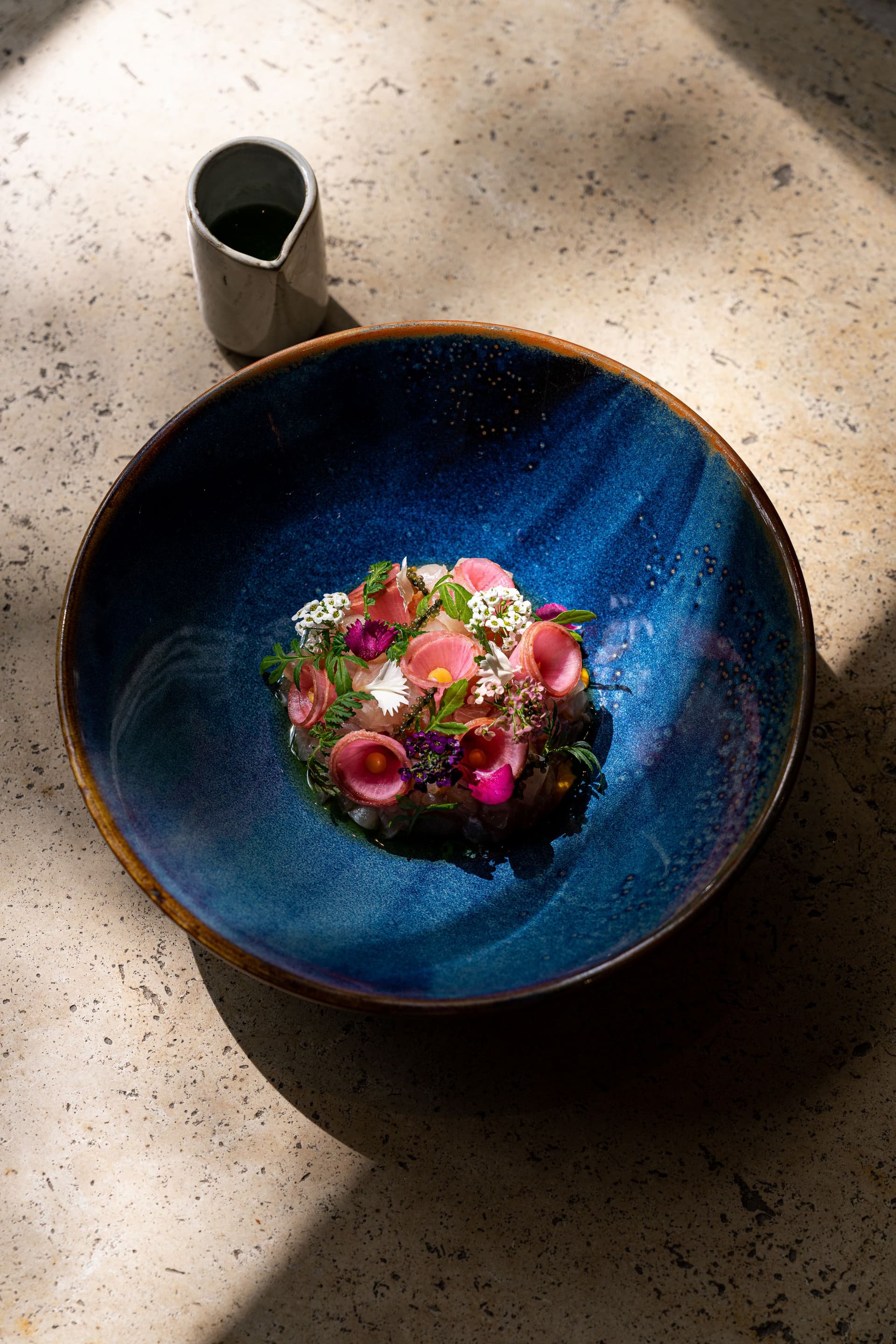 Plat gourmet dans une assiette bleue artistique.