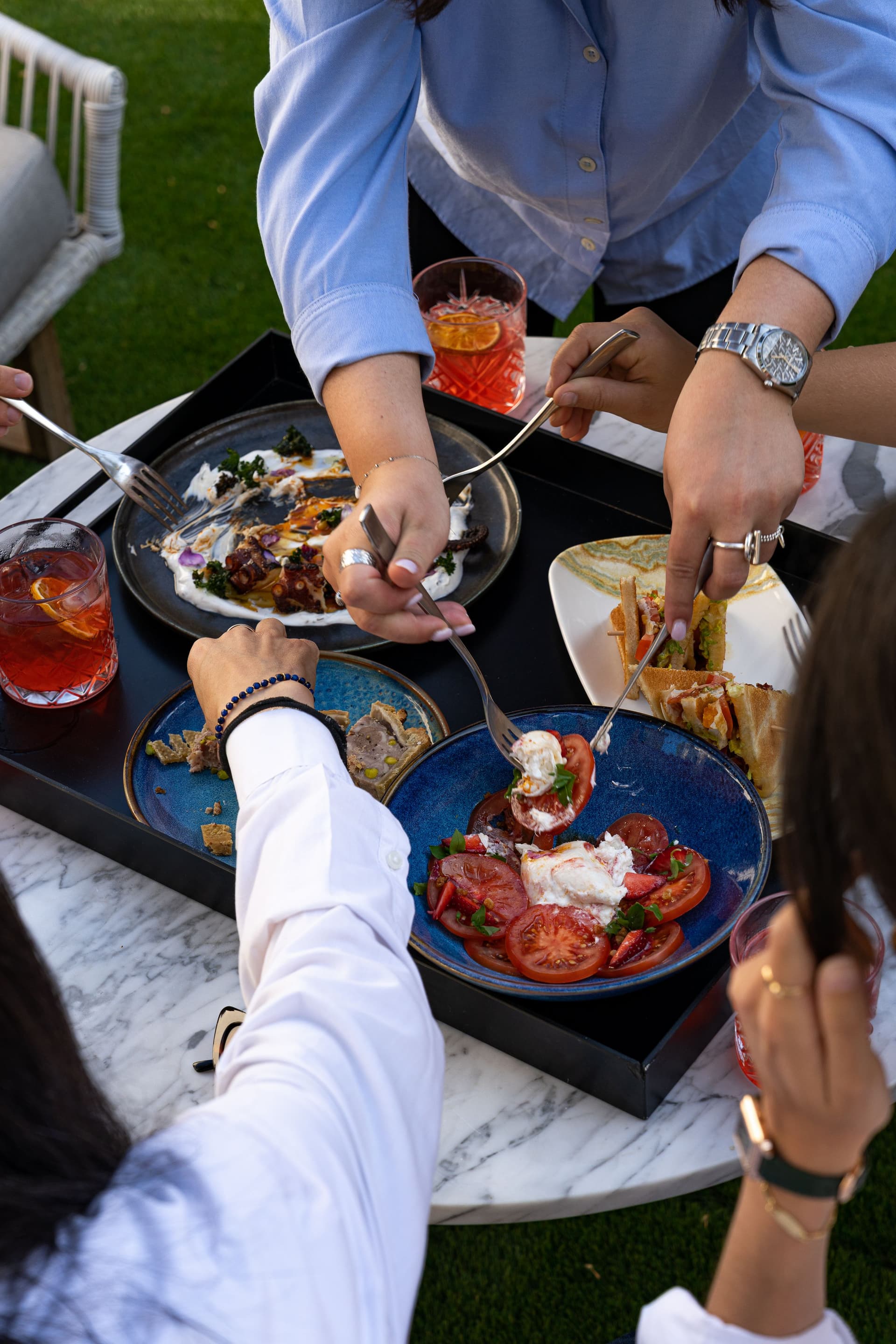 Personnes partageant un repas convivial en extérieur.