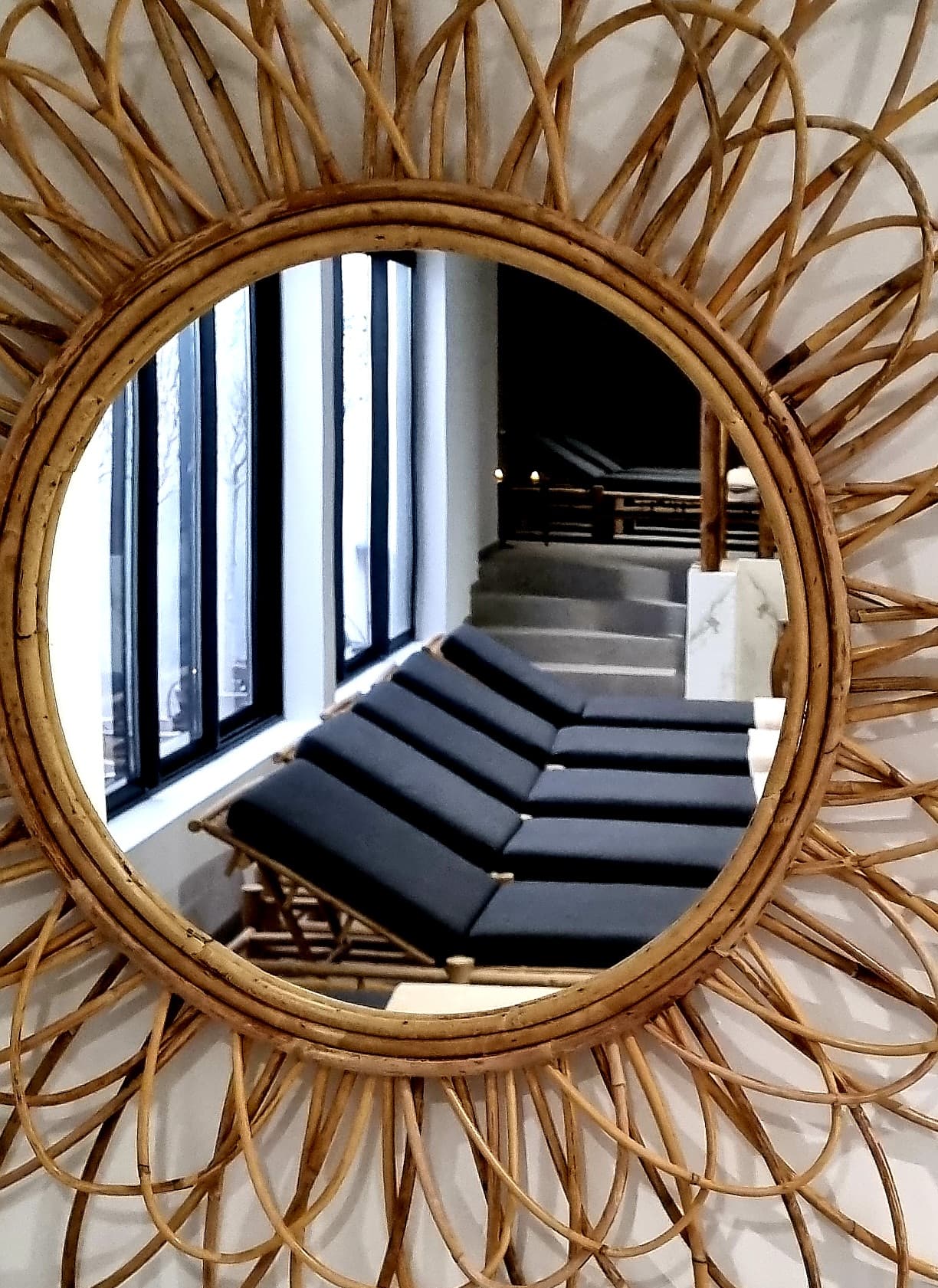Miroir en rotin refletant fauteuils inclinables.