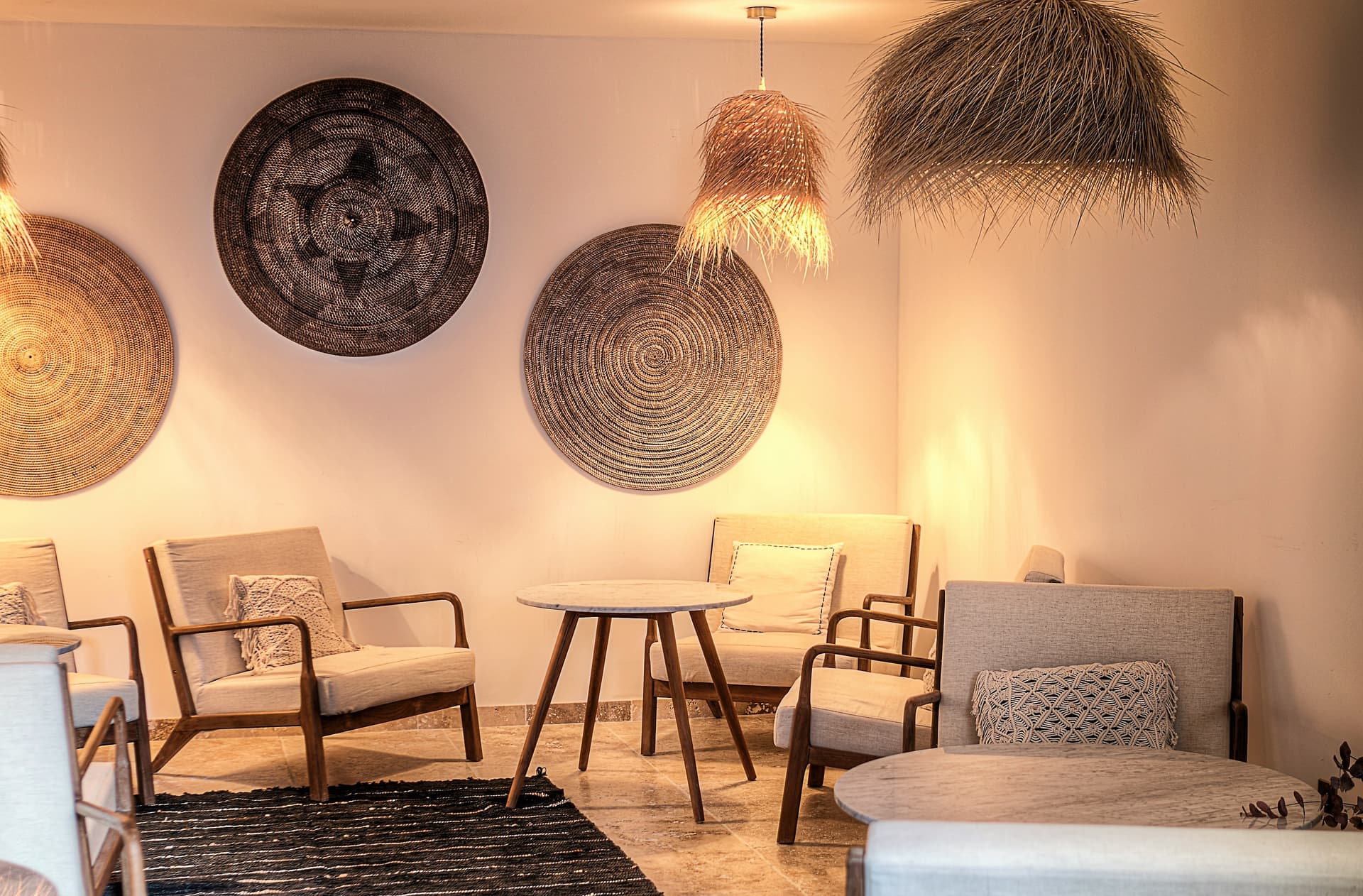 Salon avec décor mural circulaire et fauteuils en bois.